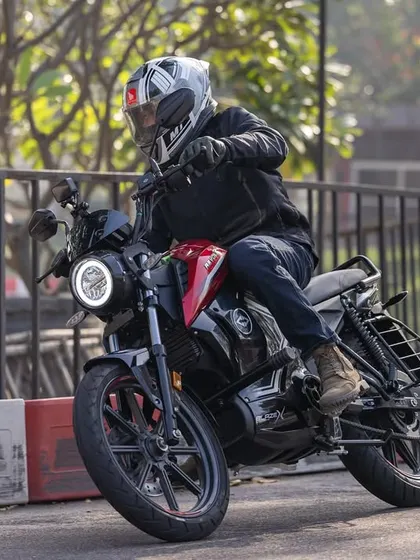 A side profile action shot of the Revolt motorcycle, providing a clear view of its design and features while in motion.