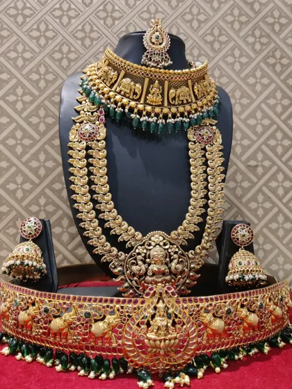 A stunning bridal set featuring an elephant-motif choker and a Lakshmi haram, all in an antique gold finish.