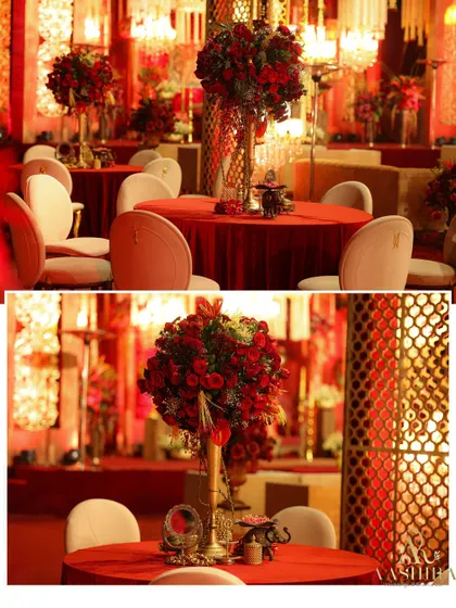 A closer look at the guest tables, where tall arrangements of red roses stood on tables covered in rich red linen, creating a dramatic and romantic dining atmosphere.
