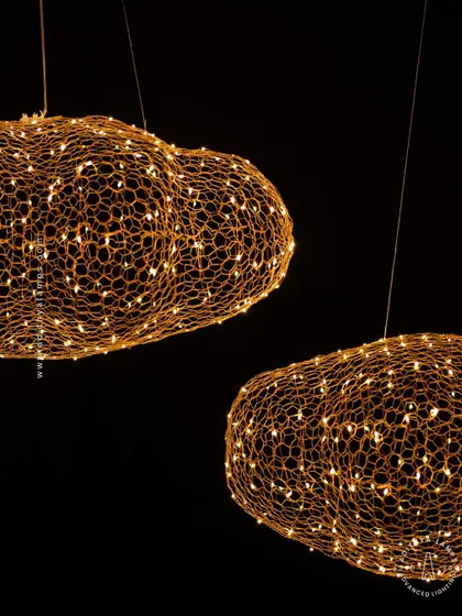 We call this piece the 'Clouds of Abundance'. Formed from a delicate honeycomb mesh of gold wire embedded with tiny LED lights, these fixtures float like luminous clouds, casting a warm and magical glow.