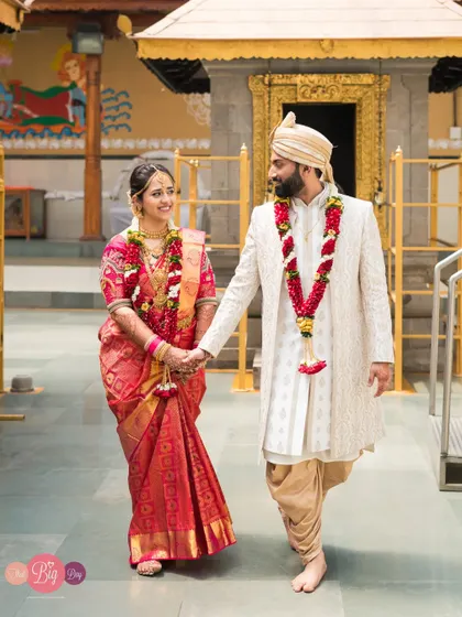 Simi and Nishith walk hand-in-hand after their beautiful temple wedding, a picture of grace and happiness.