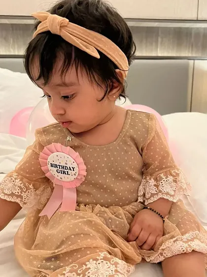 The official "Birthday Girl." This little client is wearing a custom beige polka-dot mesh dress with delicate lace trim on the sleeves, a sweet and elegant choice for her celebration.