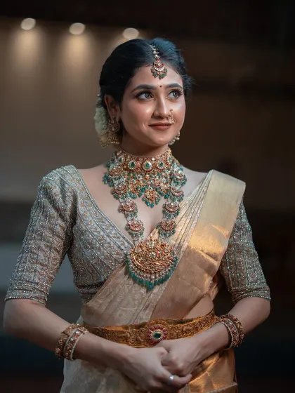 A beautiful portrait of the bride looking away with a gentle smile. The focus is on her exquisite temple jewelry and the soft, flattering light.