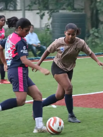 Our player demonstrates excellent ball control while being challenged by a defender in the TGIF league. This highlights the technical proficiency we build in our athletes.
