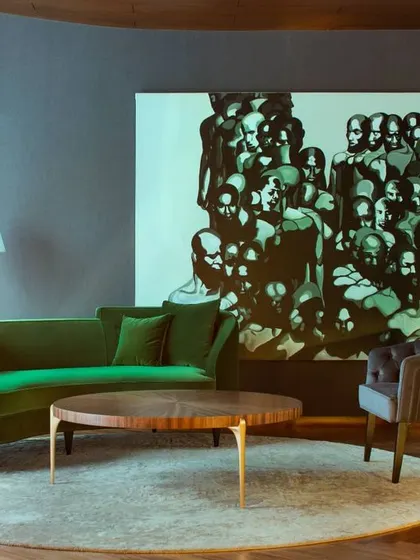 Art plays a vital role in this contemporary New Delhi residence. Here, a dramatic green sofa and a large-scale painting create a powerful, moody composition in this intimate seating area, showcasing how we design spaces around key art pieces.