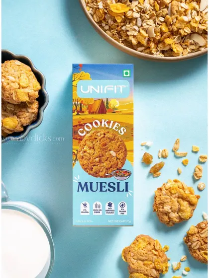 A Unifit muesli cookie box, shot against a light blue background with muesli and milk.