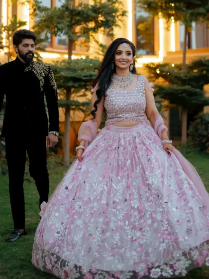 A fairytale reception look. The bride's flowing pastel lehenga and soft, romantic makeup make her look like she's stepped out of a dream.