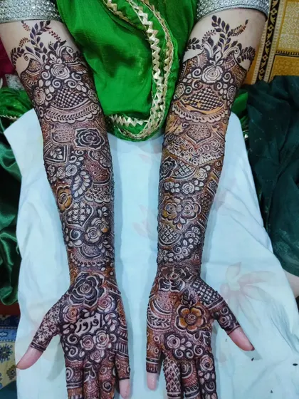 Bridal mehndi for Fazila, with her groom's name, Feroz, surrounded by roses. The design is rich and traditional.