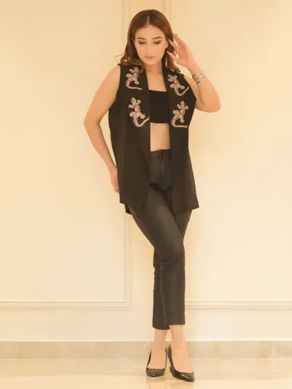 This pose highlights the fit and style of the black vest and trousers combination, perfect for a lookbook or social media feature.