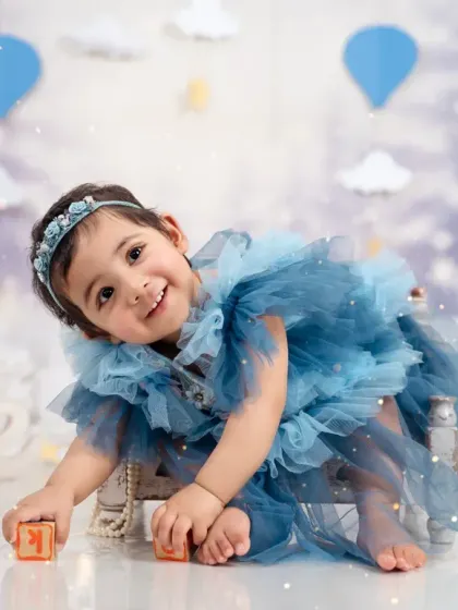 Playful and sweet, this little one is all smiles during her first birthday photoshoot, surrounded by dreamy props.