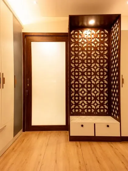 A stunning pooja unit from Bhavinee's home, featuring intricate dark wood *jaali* work. This piece serves as a beautiful and spiritual focal point in the room.