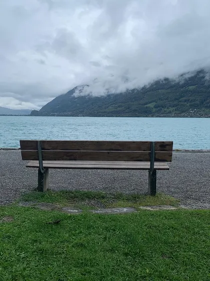 An empty bench by the shimmering water of Lake Brienz in Switzerland. A scene that feels like a poem, a space for quiet thoughts on intimacy and connection.