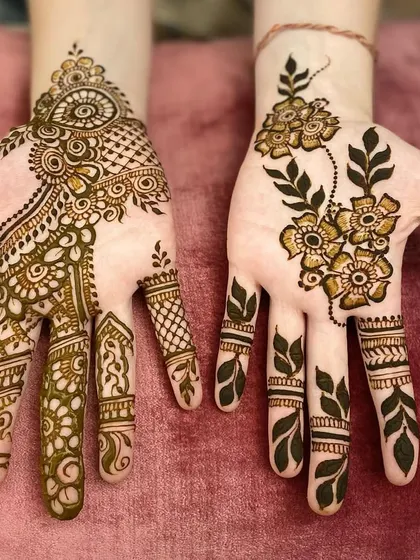 Two different styles for guests. One hand features a delicate Arabic floral vine, while the other has a more detailed Indo-Arabic design.