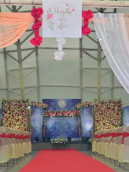 A full view of a wedding setup inside a semi-open resort hall. We used a combination of drapes and floral panels to create a grand stage.