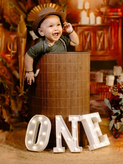 A duplicate of image 69, showing a joyful baby boy with light-up "ONE" letters in a rustic studio setup.