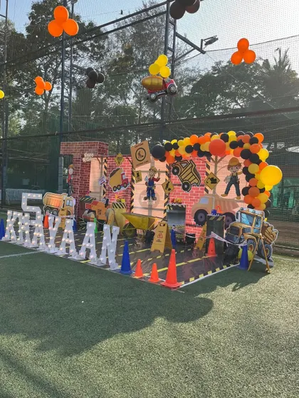 Caution: Fun ahead! This construction-themed birthday party features a massive backdrop with trucks and cranes, a lit-up name, and a '5' for the birthday boy.