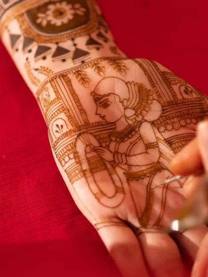 A work-in-progress shot of the Kannada bride figure being drawn. This behind-the-scenes look shows the artistry and steady hand required for such detailed work.