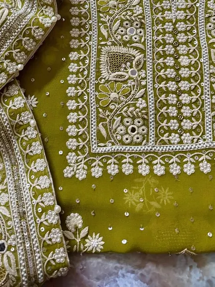 A flat-lay of the suit, showing the dense embroidery on the kurta and the matching work on the dupatta border.