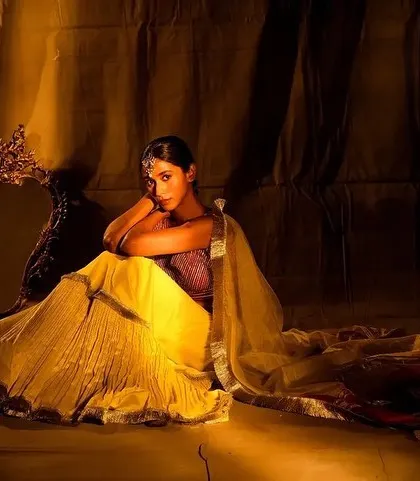 A full-length shot capturing the dramatic and moody aesthetic of the Nayantaara campaign. The makeup is subtle yet effective, with a focus on glowing skin and defined features.