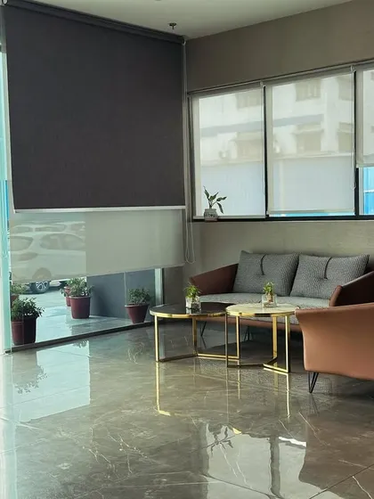 This waiting area is designed to feel open and bright, with large windows allowing for plenty of natural light. The neutral-toned sofas and minimalist coffee tables create a calm and professional atmosphere for visitors.