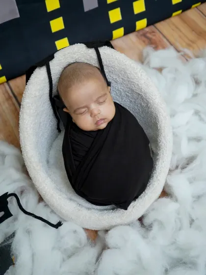 A wider view of the Batman-themed newborn setup, showing the cityscape background and bat symbols scattered in the 'clouds'.