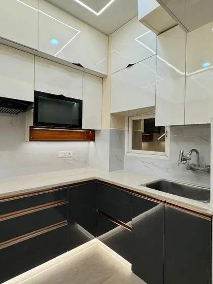 A closer look at the details of this U-shaped modular kitchen, showing the seamless integration of the microwave unit and the clean lines of the handleless cabinets.