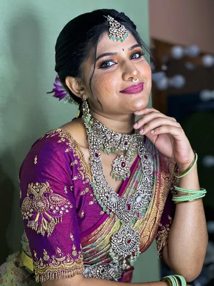A stunning bridal look created in collaboration with a makeup artist, featuring a purple and green silk saree and heavy silver jewelry. This is a great inspiration for a unique bridal look.