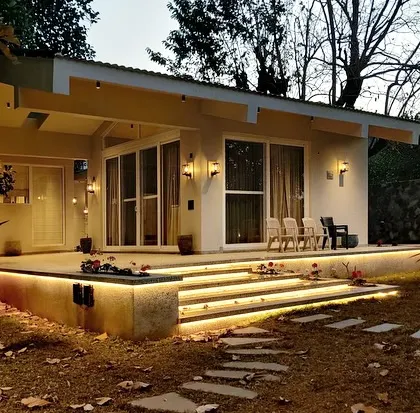A cozy and well-lit outdoor seating area at the Amberle farmhouse. The lighting is designed to be functional for evening relaxation while maintaining a soft, natural feel.