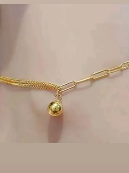 A trendy mixed-chain anklet featuring a small bell charm. This piece combines a snake chain and a paperclip chain for a unique look.