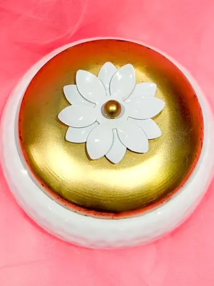 A top-down view of the metal box lid, highlighting the delicate white lotus flower detail that makes this box a special keepsake.