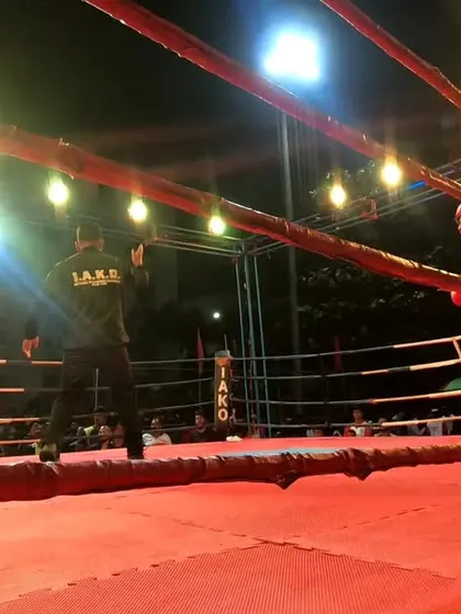 The referee watches closely as the fighters exchange blows.