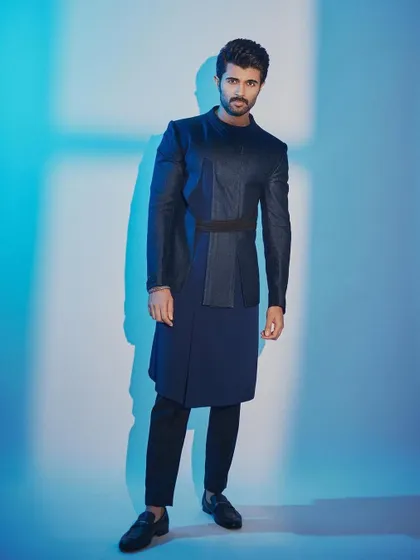 A full-length view of Vijay's trailer launch outfit. The layered, deep blue ensemble is both striking and sophisticated.