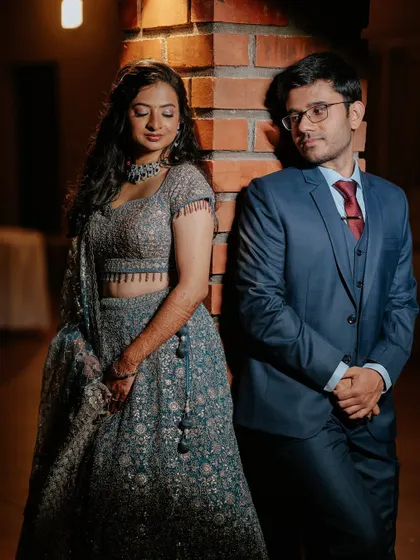 A modern, artistic couple's portrait. Her makeup is kept soft and romantic, creating a beautiful contrast with the industrial-chic brick background.