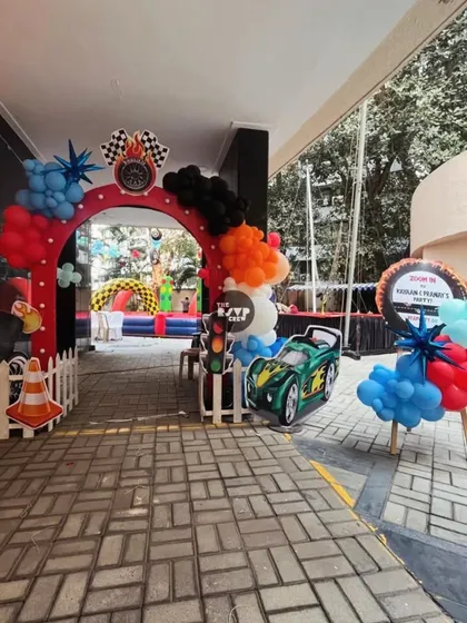 The entrance to the Hot Wheels race, featuring a checkered flag arch, a traffic light prop, and a cool green race car.