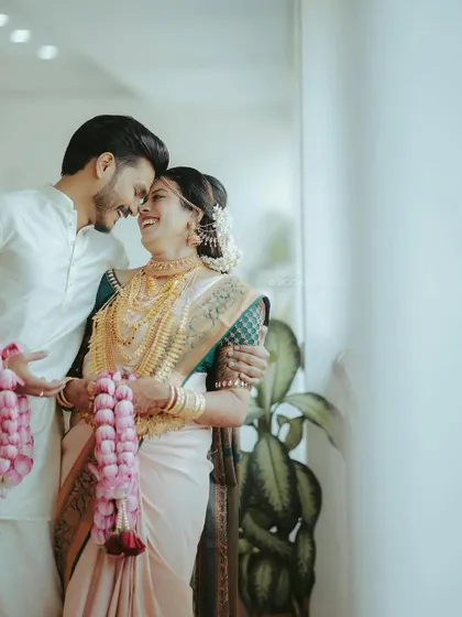 A romantic shot of the happy couple. The groom's simple and elegant white kurta look was perfect for their traditional wedding.