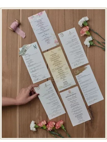 A selection of custom menu cards we have designed. This shows the variety of styles we can create, from minimalist designs with a simple monogram to more elaborate floral and graphic themes.