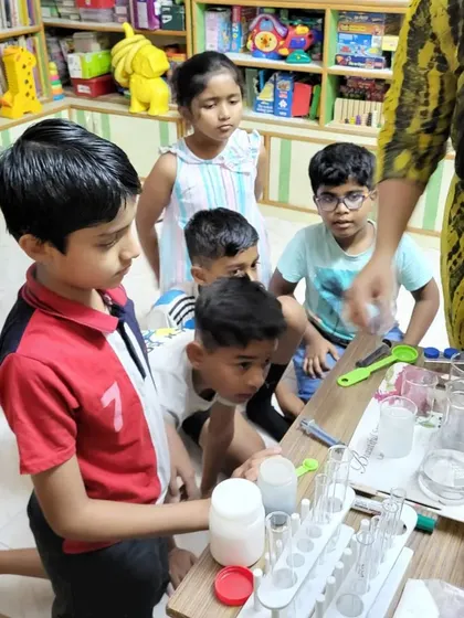 An instructor guides a group of children through a chemistry experiment.