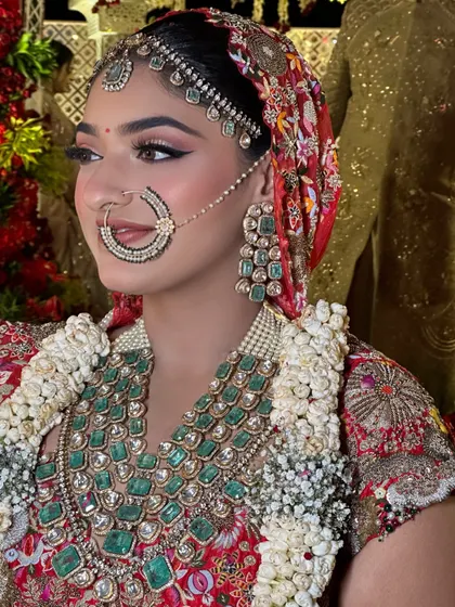 This bride's look was a beautiful blend of tradition and modernity. Her Anamika Khanna lehenga was paired with a unique printed dupatta as a head veil, complemented by bold eyes and stunning emerald jewelry.
