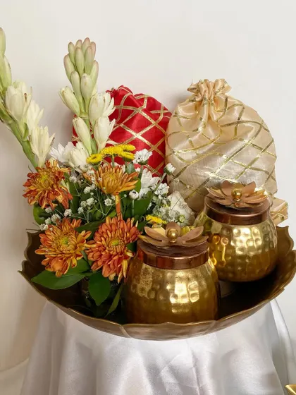 A close-up of the urli hamper, focusing on the fresh rajnigandha (tuberose) and the handcrafted brass jars. It’s a gift that engages all the senses.