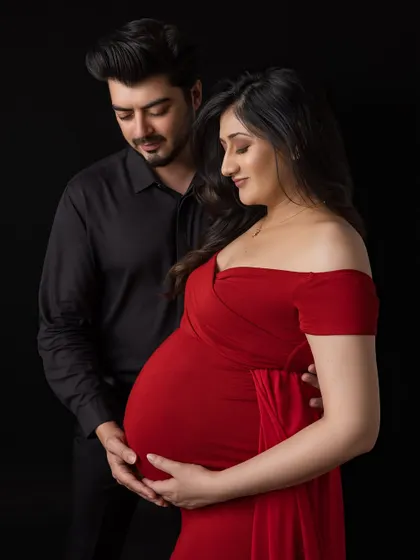 A close-up portrait filled with anticipation. The couple looks down at the baby bump together, their expressions full of love and wonder, creating a powerful and emotional maternity photograph.