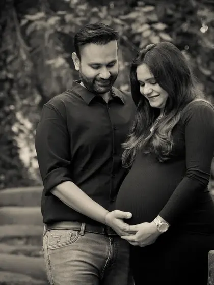 Another beautiful black and white maternity shot. The couple stands together, hands gently placed on the baby bump, creating a simple, powerful, and intimate portrait.