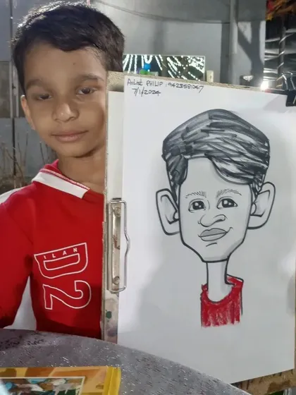 A young boy from the birthday party, holding his caricature.