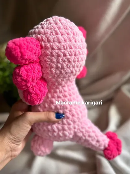 The back of our pink axolotl plushie, showing its signature gills. We use two shades of pink to create a vibrant, eye-catching look. The chunky yarn makes it incredibly soft to the touch.