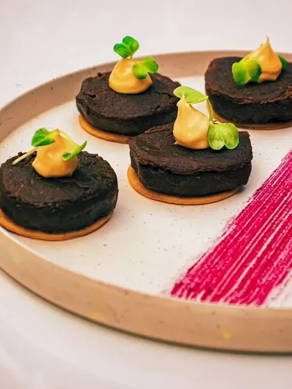 A beautifully plated modern dessert, showcasing our pastry team's artistic skills. These are small, bite-sized cakes, perfect for a sophisticated dessert buffet.