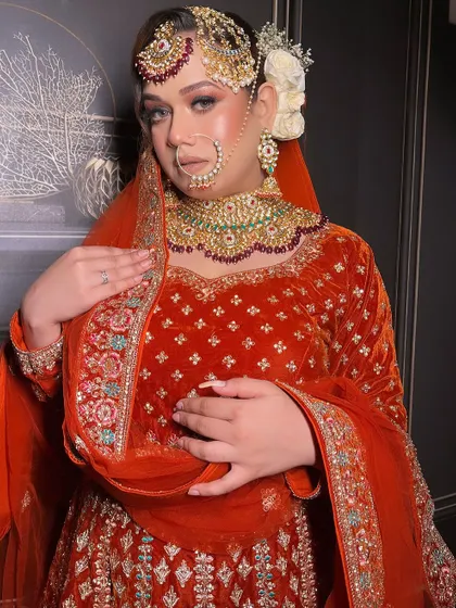 A beautiful bridal portrait in the orange velvet outfit, highlighting the makeup and passa.