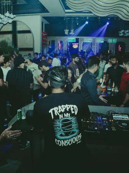 A view from behind the decks, showing the entire club vibing to the music.