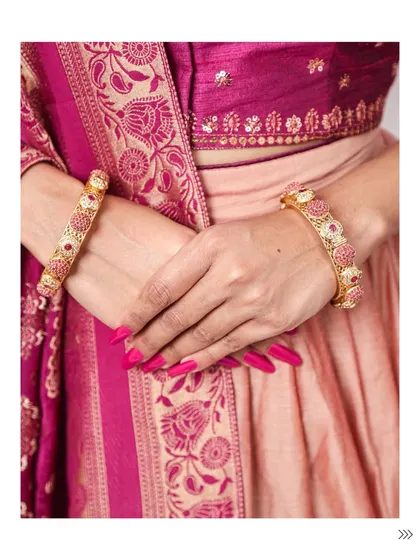 A detail shot of beautiful pink and gold bangles paired with a traditional silk outfit. The right bangles can completely elevate an ethnic look.