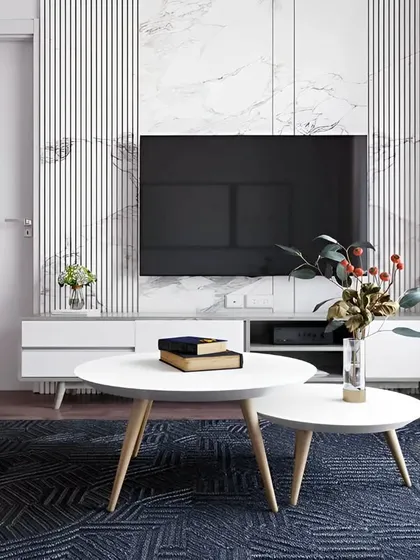 This minimalist living room design features a clean, white TV unit against a backdrop of fluted and marble-finish panels. The simple lines and neutral color palette create a serene and uncluttered space, perfect for relaxation.
