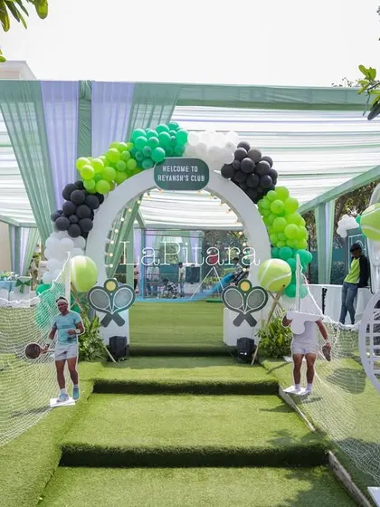 Another angle of the impressive tennis court entrance, showing the turf-lined path and themed archway.