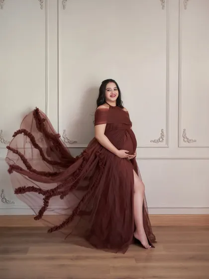 A full-length shot of the Renee gown. The off-shoulder design and ruffled trail create a dramatic and beautiful silhouette.